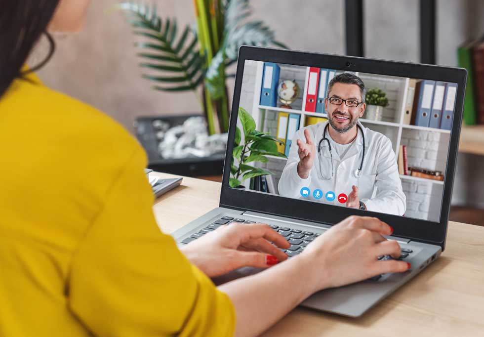 Paciente realizando una videoconsulta con un médico a través de su portátil, ejemplo de digitalización y marketing médico y sanitario.