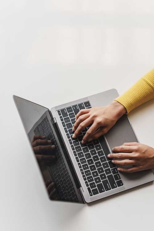 Persona trabajando en diseño y desarrollo web en un ordenador portátil escribiendo contenidos web de calidad